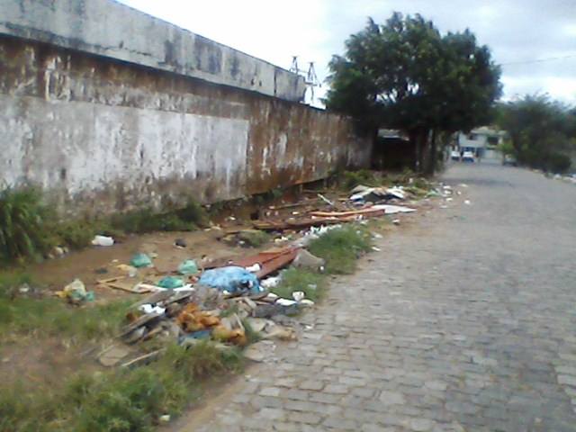 Vejamos a situação lastimável da entrada do necrotério do hospital geral Luiz Viana Filho, em Ilhéus. Como é possível ver na imagem, o mato e o lixo tomaram conta o local. Cadê a secretaria municipal competente? Foto: Waldemir Correia.